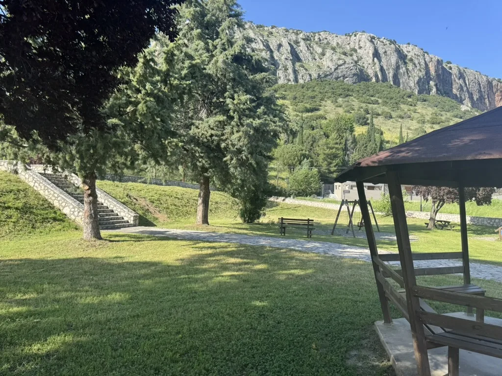 Εξωτερικός κήπος του Cave Garden με ξύλινο κιόσκι και εξέδρα για live events